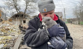 FOTO // Un ucrainean își ţine în braţe pisica, singurul membru al familiei rămas în viaţă, după bombardamentele ruşilor: „Fiica mea a murit în scaunul cu rotile”